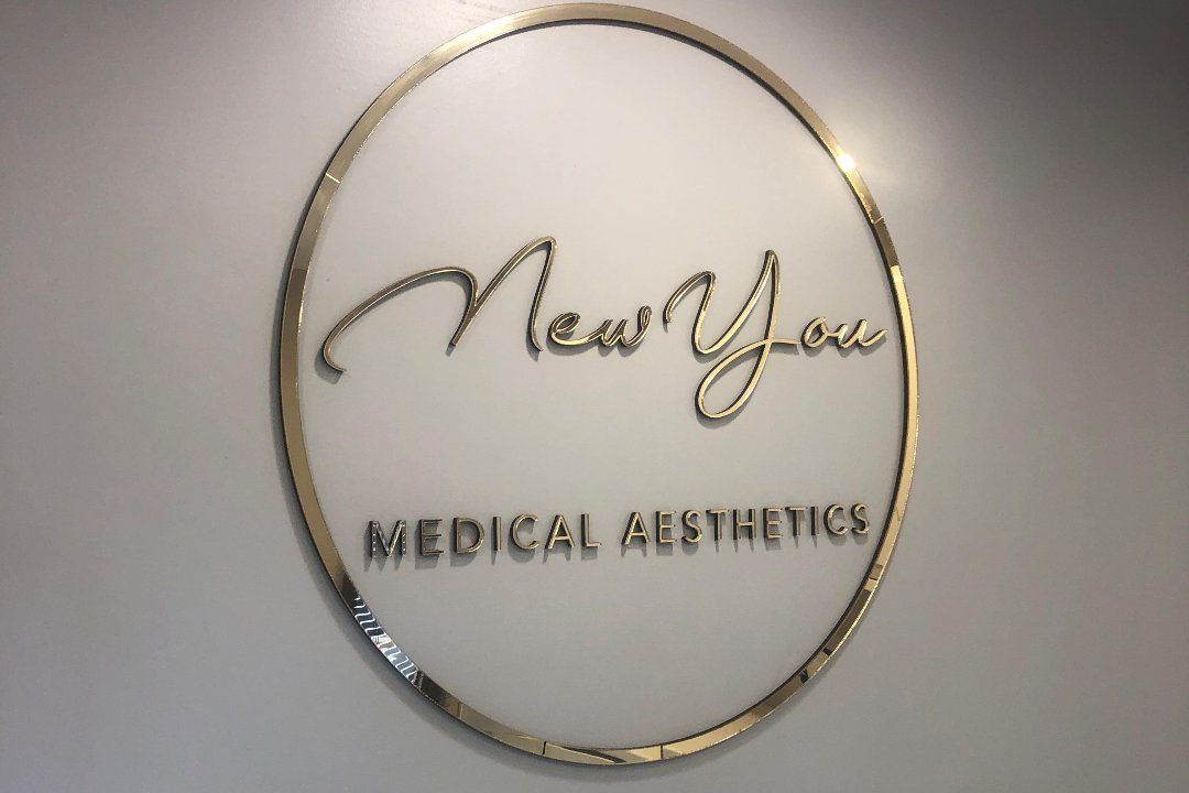 The New You Medical Aesthetics gold ring sign on the wall of the clinic in Bromley Cross, Bolton.
